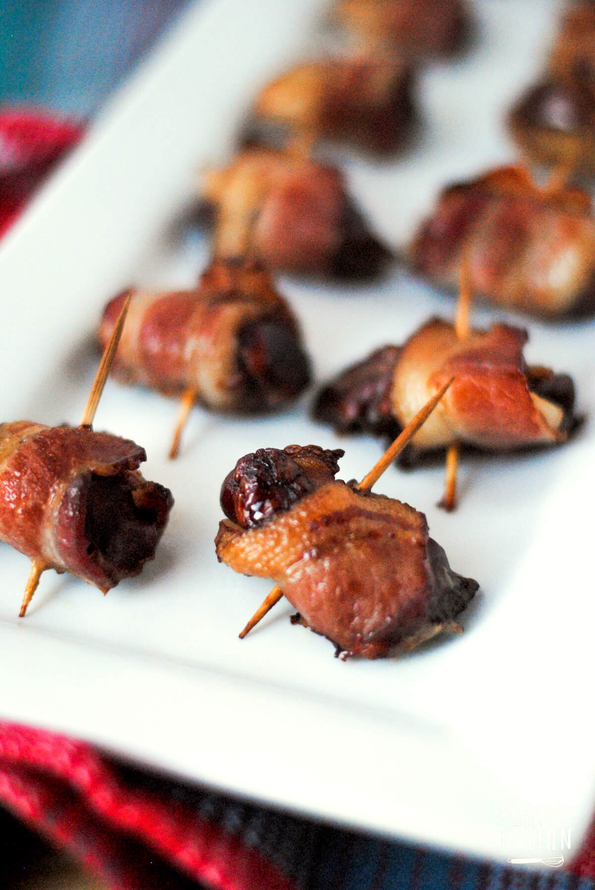 Close-up of bacon-wrapped chicken liver rumaki on a rectangular white platter