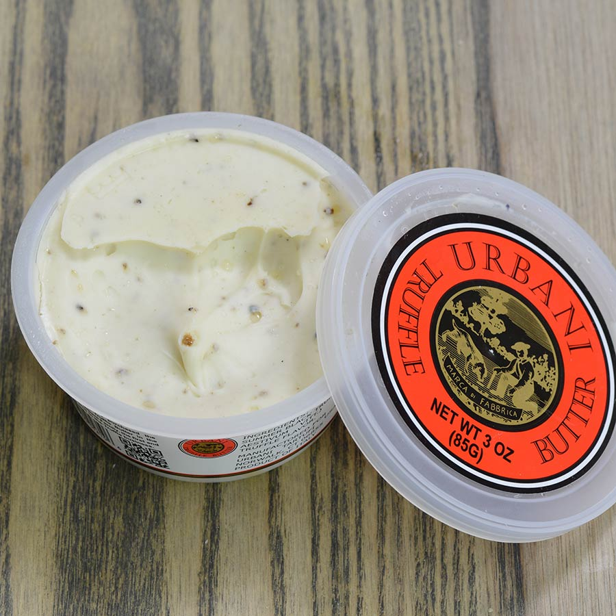 Open container of The Urbani truffle Butter with visible brand label on a wooden surface
