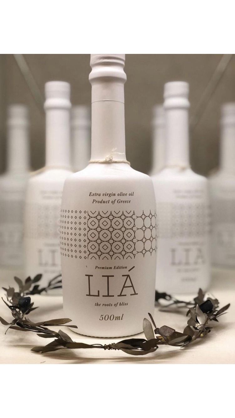 Bottle of Lia olive oil with decorative elements on a white background