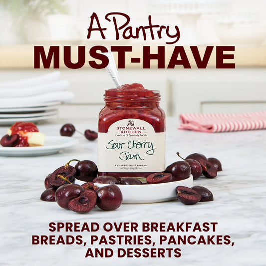 Jar of Sour Cherry Jam with cherries on a table, labeled as a 'Pantry Must-Have' for spreading on breakfast items.