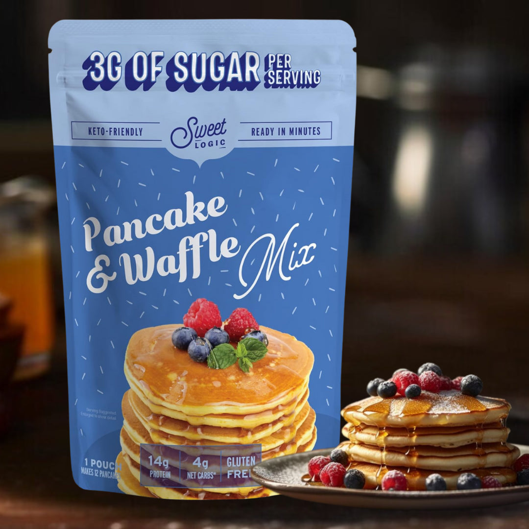Sweet Logic Pancake & Waffle Mix in a blue resealable pouch, shown with two stacks of pancakes topped with berries and syrup on a plate in a warm, blurred kitchen setting.