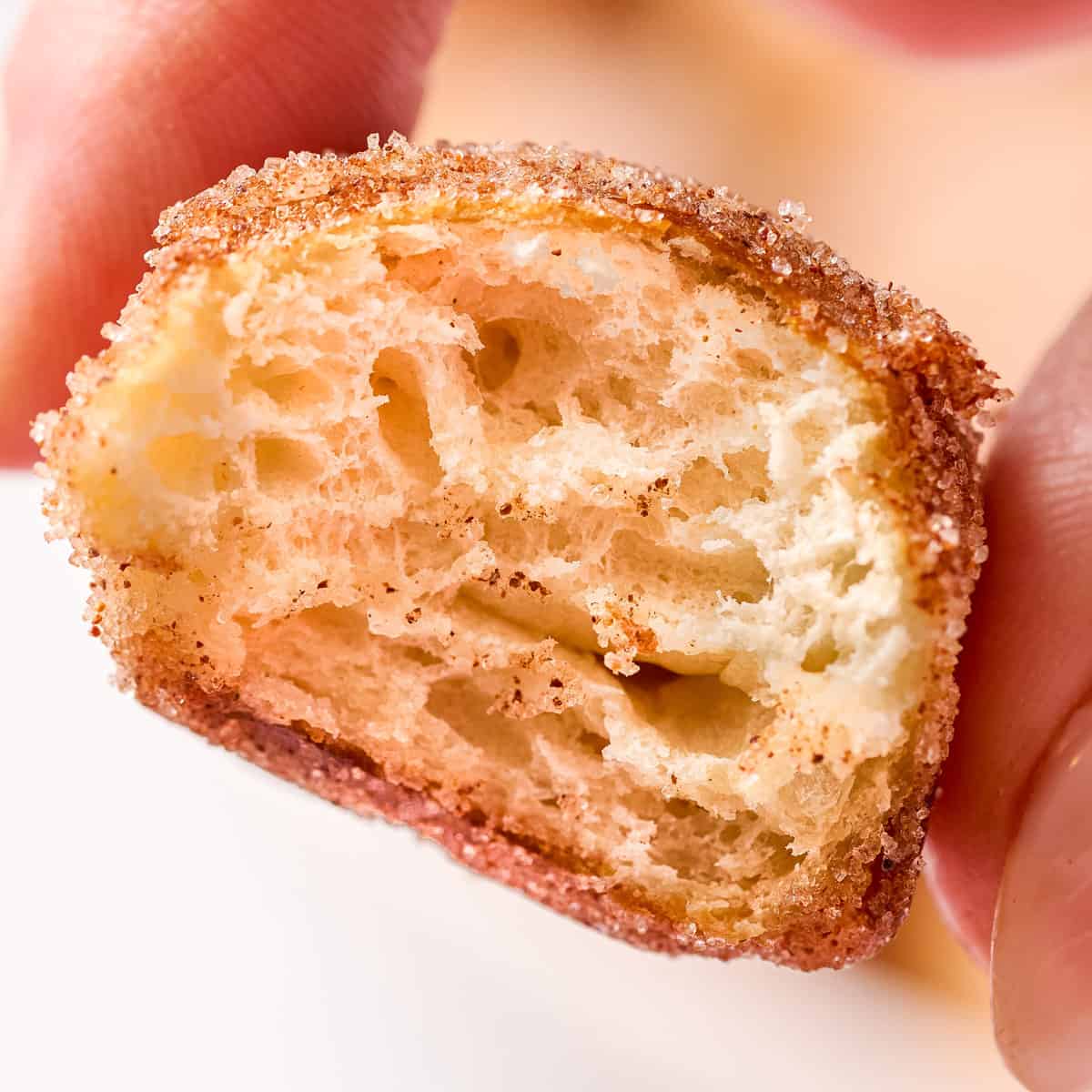 Close-up of a bitten sugar-coated pretzel bite showing its soft interior.