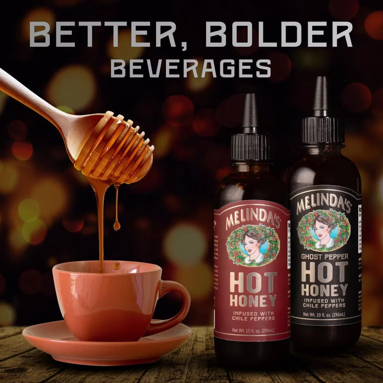Honey dripping from a dipper into a cup beside Melinda’s Classic and Ghost Pepper Hot Honey bottles

