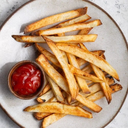Overhead view of fries with a small bowl of ketchup, serving suggestion
