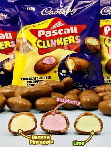 Pascall Clinkers pouches behind cut chocolate-coated candies showing yellow, pink and green centres.