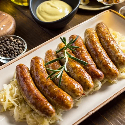 Six browned sausages on shredded cabbage, garnished with rosemary.