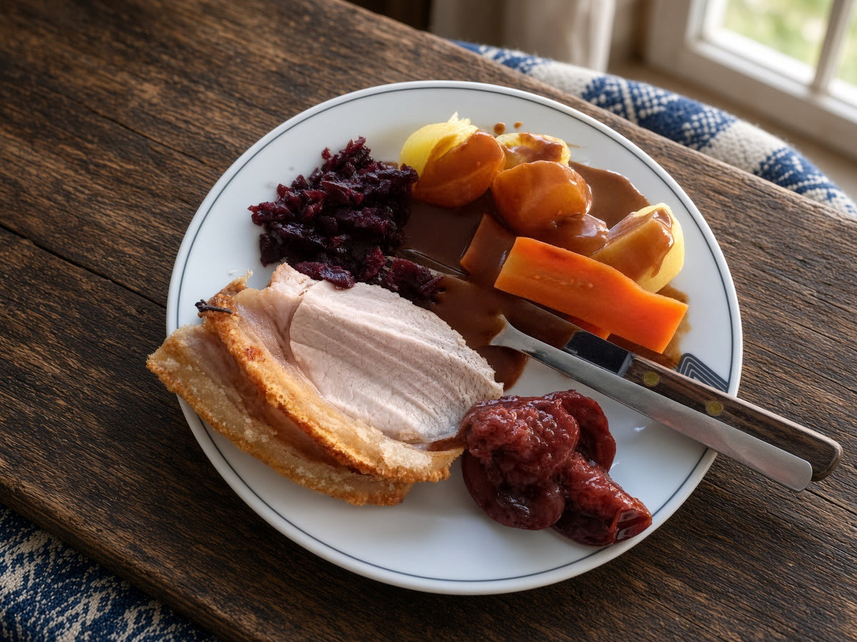  plate with carrots: Danish holiday meal inspiration with sliced roast pork, crackling, potatoes, carrots, red cabbage, and gravy