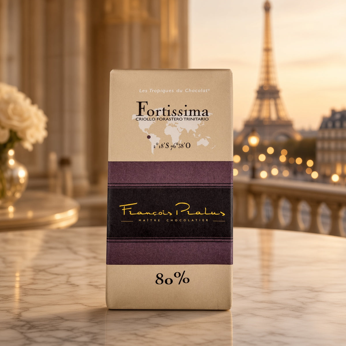 François Pralus Fortissima 80% dark chocolate bar in cream and purple packaging standing upright on a marble surface with a blurred Parisian balcony and Eiffel Tower in the background