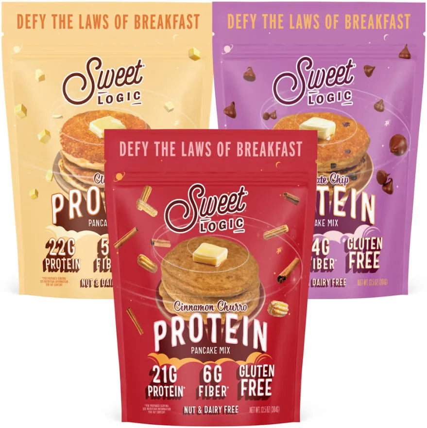 Three Sweet Logic protein pancake mix pouches arranged together on a white background: a yellow pouch on the left, a purple pouch on the right, and a red front-facing pouch in the center labeled Cinnamon Butter Protein Pancake Mix.