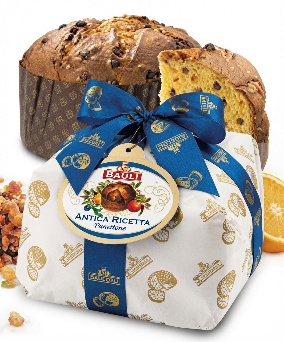 Bauli Antica Ricetta Puncetone sweet bread loaf wrapped in white paper with blue ribbon and gold print, with a sliced piece showing the golden crumb and chocolate-like inclusions, set against a loaf of the same bread.
