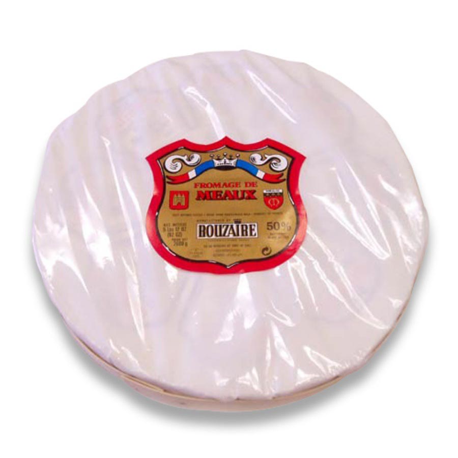 A round wheel of Fromage de Meraux Roizatbe cheese, wrapped in clear plastic with a prominent red and gold shield-shaped label in the center, set against a plain white background.