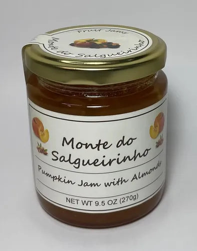 A glass jar of Monte do Salgueirinho Pumpkin Jam with Almonds, featuring a white label and a gold metal lid, set against a plain light gray background.