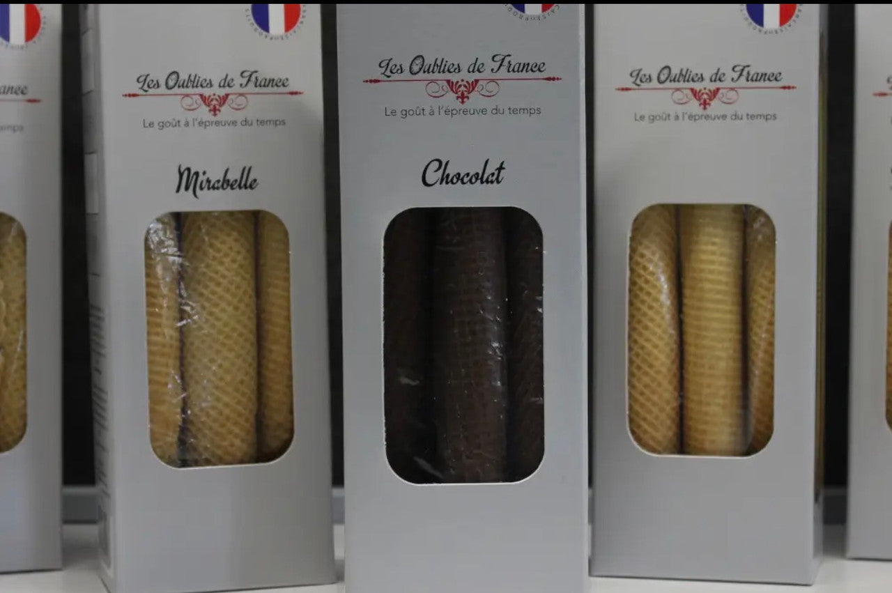 Three white boxes of French artisanal sticks, featuring 'Les Outils de France' branding. The center box is labeled 'Chocolat' and contains dark brown chocolate sticks, while the side boxes are labeled 'Misebelle' and contain golden-brown waffle sticks.