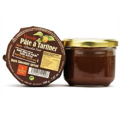 A jar of Verritable Pâte à Tartiner dark chocolate spread, with the gold-lidded glass jar on the right and the brown paper lid leaning against it on the left, on a white background.