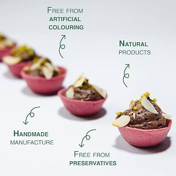 Chocolate tartlets in pink pastry cups arranged on a white background with marketing text overlays reading 'Free from artificial colouring,' 'Natural products,' 'Handmade manufacture,' and 'Free from preservatives.'.