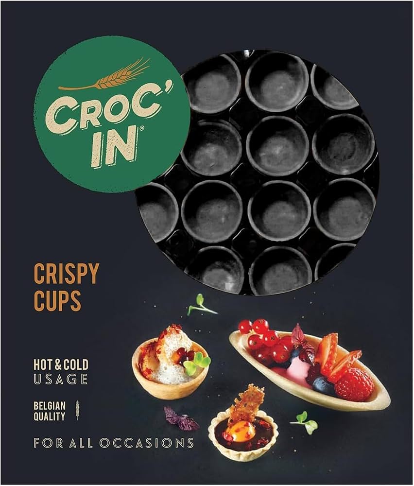 Croc' In Crispy Cups packaging on a dark charcoal background, featuring a green brand logo, a circular cutout showing the black crispy cup molds, and three small food serving examples with fruit and desserts.