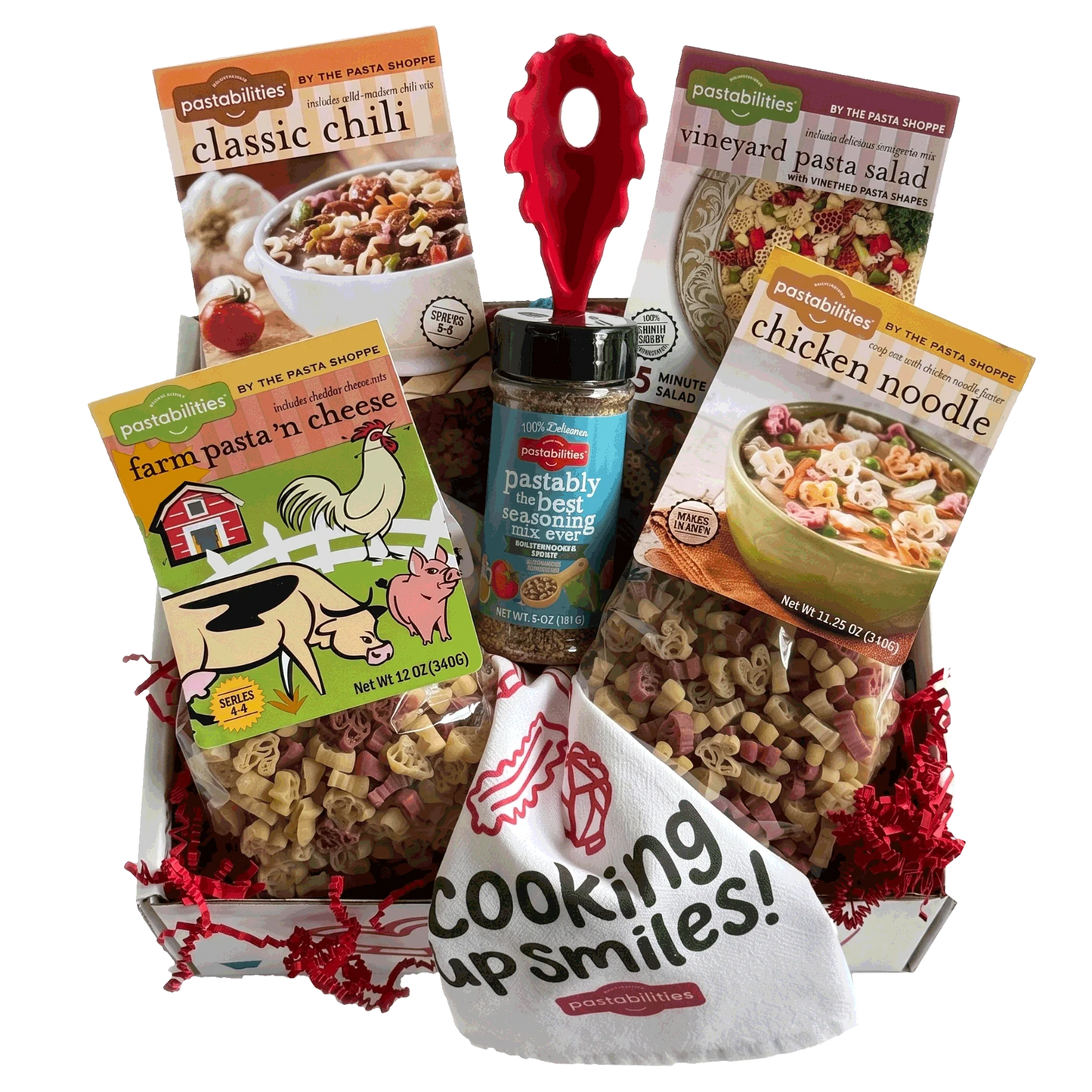 A gift basket filled with pasta products from Pastabilities, including Classic Chili, Vineyard Pasta Salad, Farm Pasta 'n Cheese, and Chicken Noodle, along with a jar of best seasoning and a white bag reading 'Cooking up smiles!'.