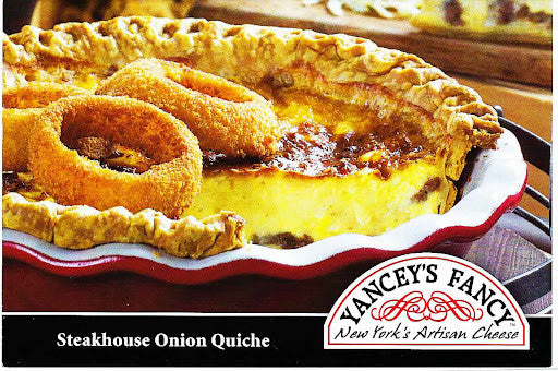 A close-up of a Steakhouse Onion Quiche pie with golden onion rings on top, served in a white dish with a red rim. The Vancey's Fancy New York's Artisan Cheese logo is visible in the bottom right corner.