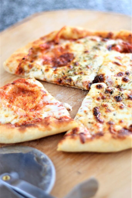 Personal-sized pizza with various toppings on a wooden board