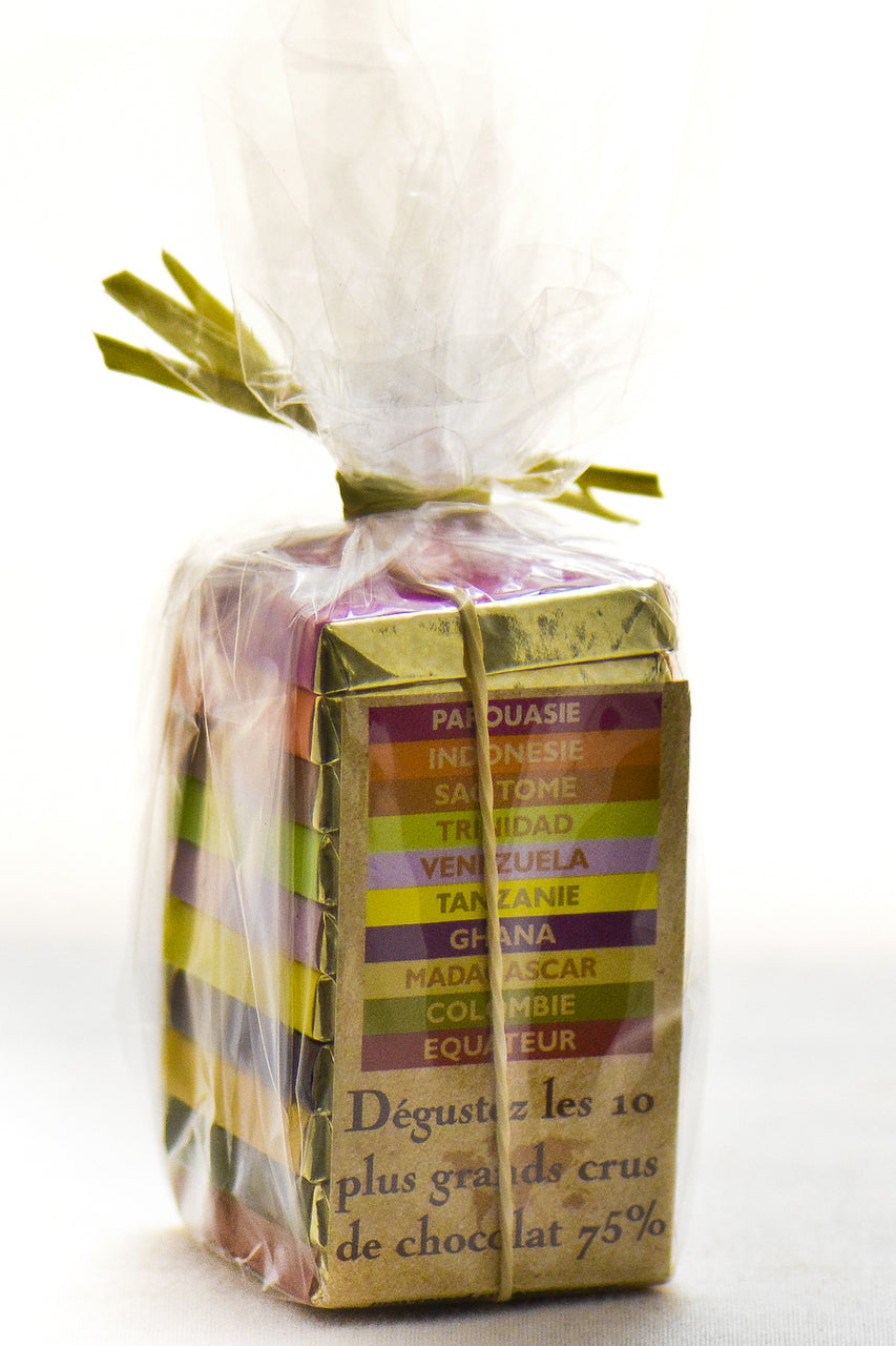 François Pralus Pyramid of the Tropics gift set — 10 mini single-origin 75% dark chocolate bars stacked in a pyramid and wrapped in clear cellophane with a green ribbon, showing origin names including Papua New Guinea, Indonesia, São Tomé, Trinidad, Venezuela, Tanzania, Ghana, Madagascar, Colombia, and Ecuador