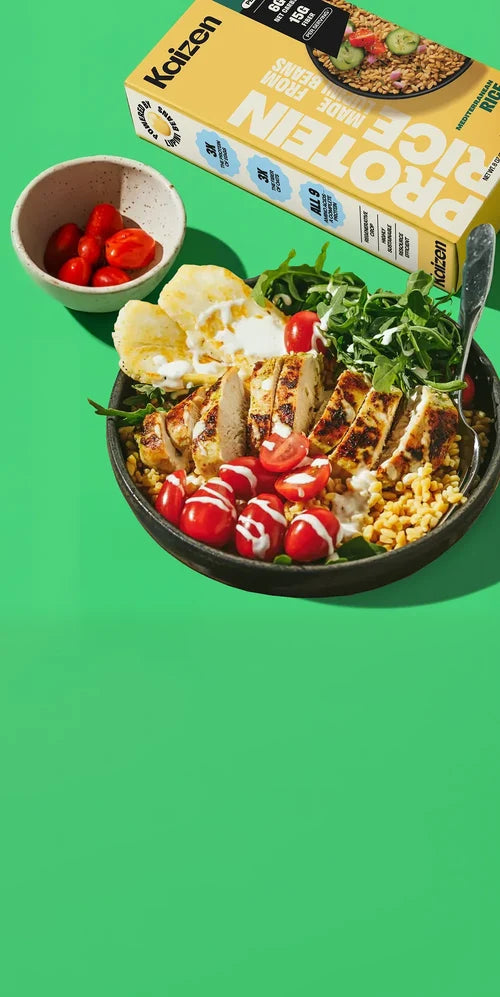 Bowl of salad with protein packaging on a green background