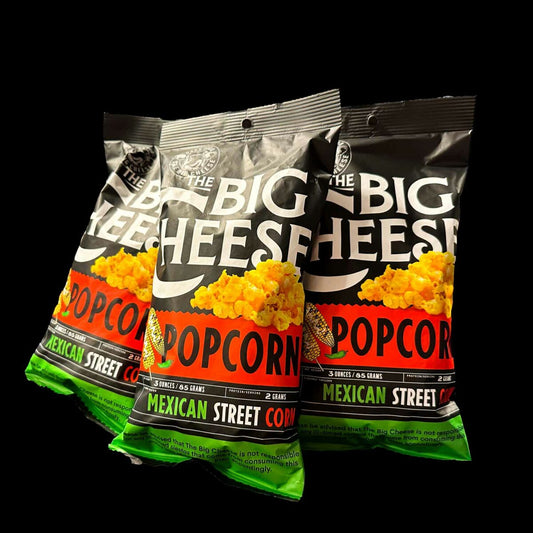 Three bags of 'The Big Cheese' popcorn with colorful labels on a black background