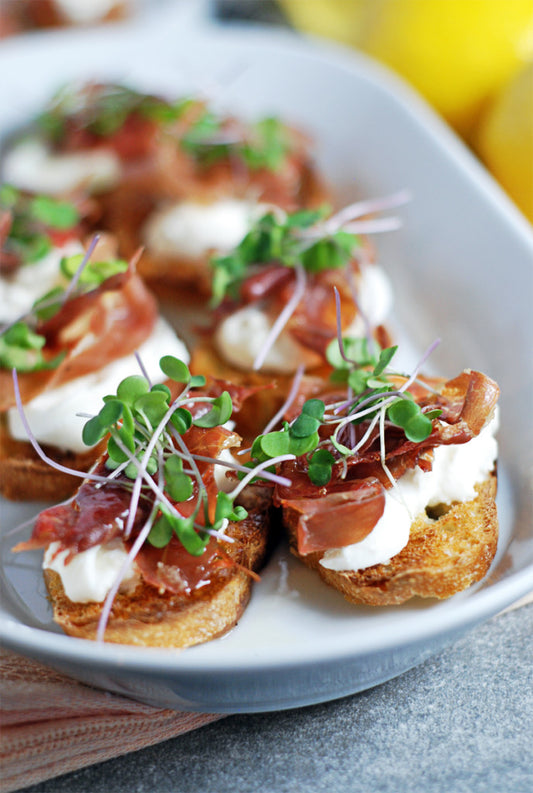 PROSCIUTTO CROSTINI WITH BURRATA AND LEMON HONEY DRIZZLE