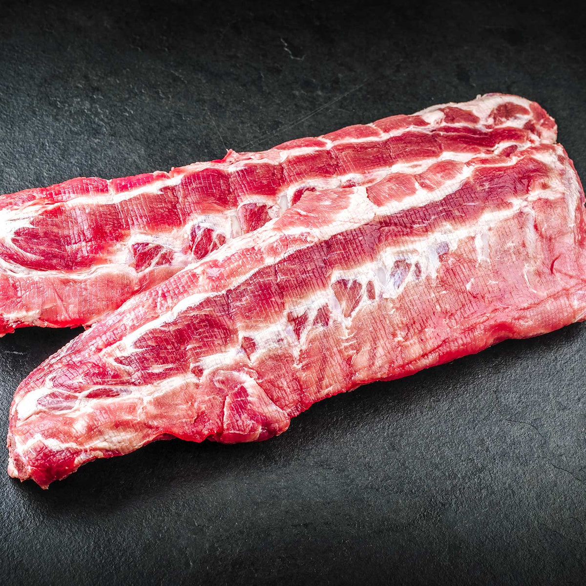 Raw ribs meat on a dark surface