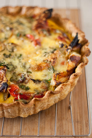 Quiche with vegetable filling on a wooden board