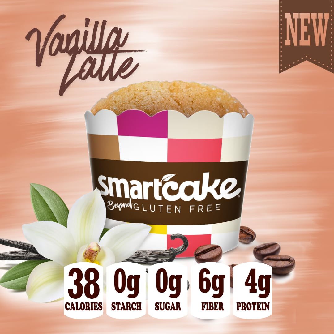 A vanilla latte-flavored muffin from smartcake, presented in a branded cup with vanilla flower, vanilla bean, and coffee bean props on a peach background. Large text reads 'Vanilla Latte' and a 'NEW' banner appears in the top right.
