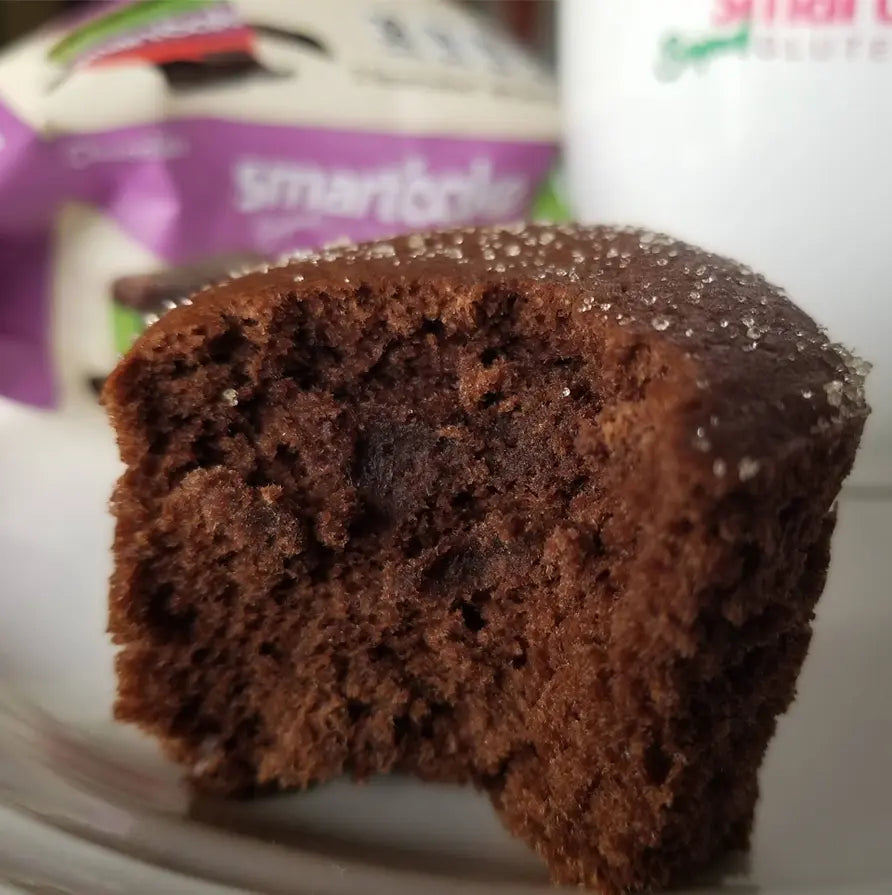 Chocolate muffin on a plate with a blurred smartfood package in the background